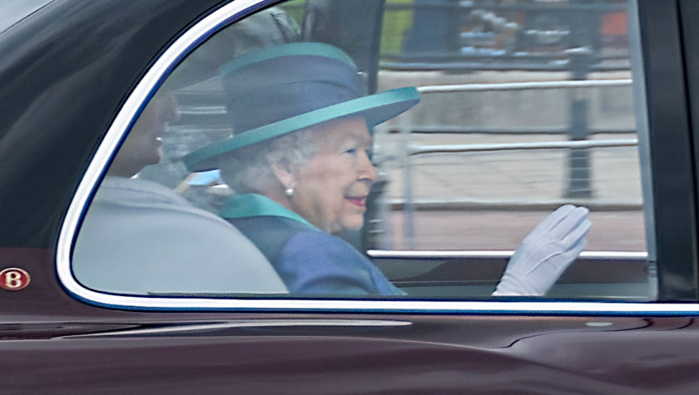 The Queen waving from a car.